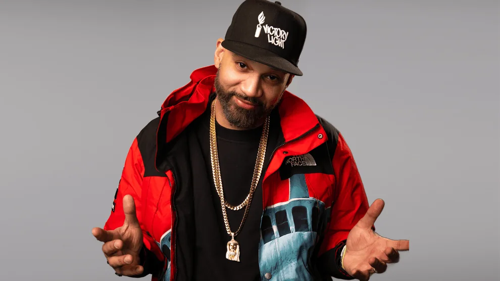 The Kid Mero in a black cap and red-and-black jacket in his official HOT 97 talent profile.