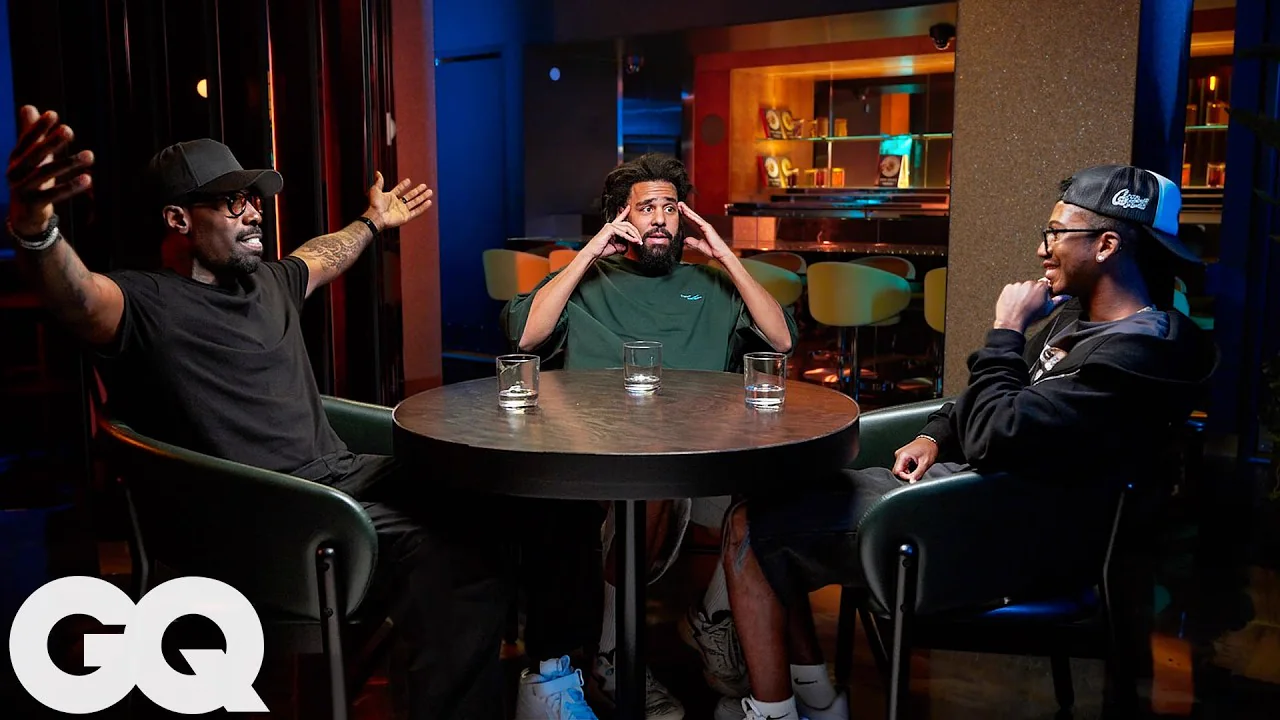 J. Cole and Mark Pitts seated for GQ’s official interview video.
