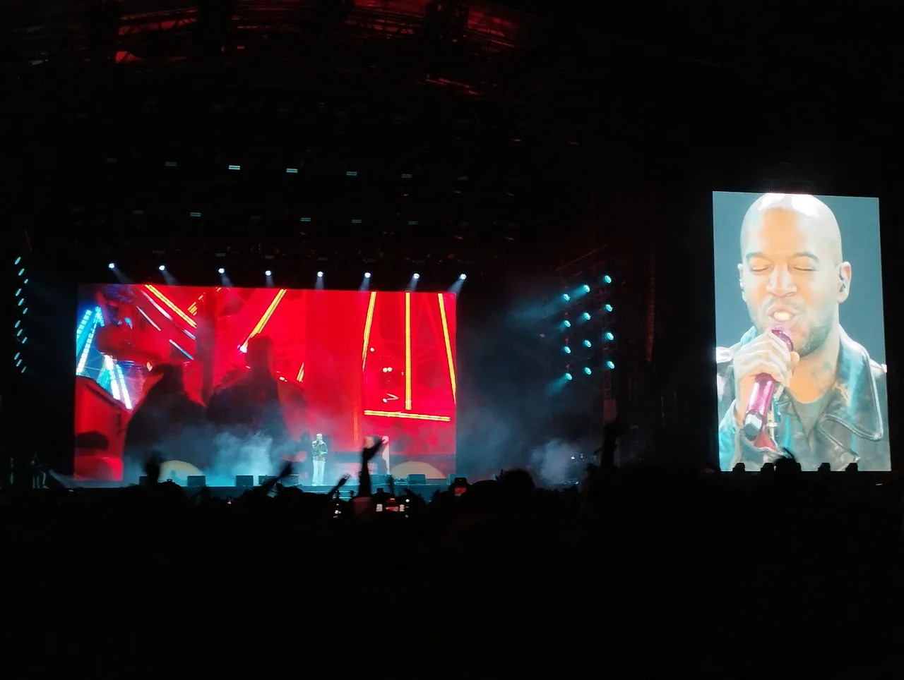 Kid Cudi performs onstage under red lighting at Rock en Seine in 2025.
