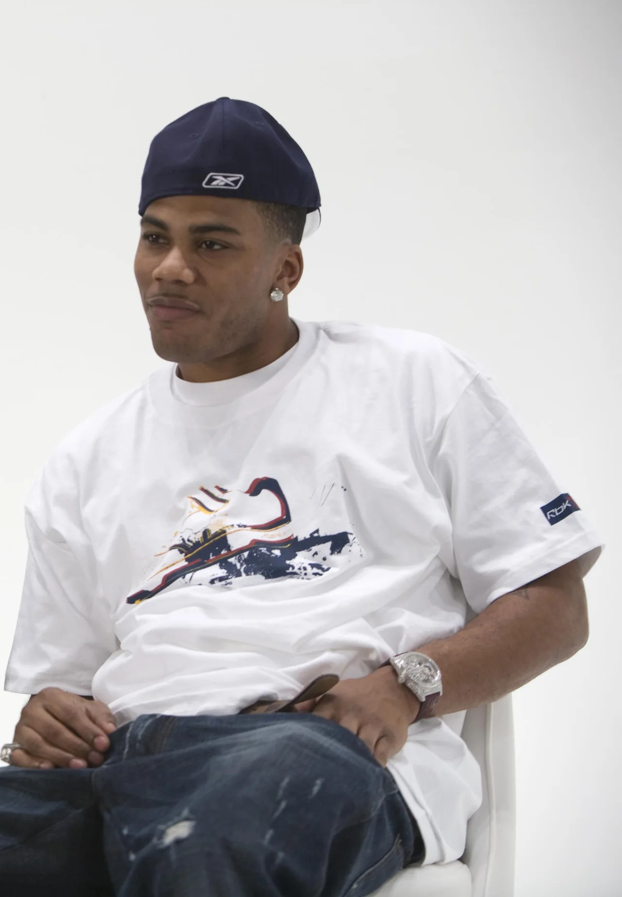 Nelly sits for a portrait in a white Reebok shirt and dark cap in 2007.