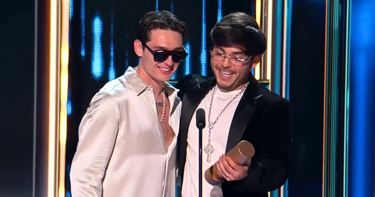 Peso Pluma and Tito Double P hold the award onstage at the 2026 Billboard Latin Music Awards.