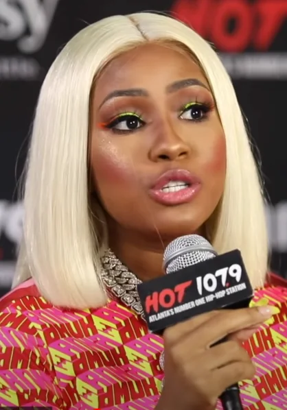 Yung Miami speaks into a HOT 107.9 microphone during a 2019 Atlanta interview.